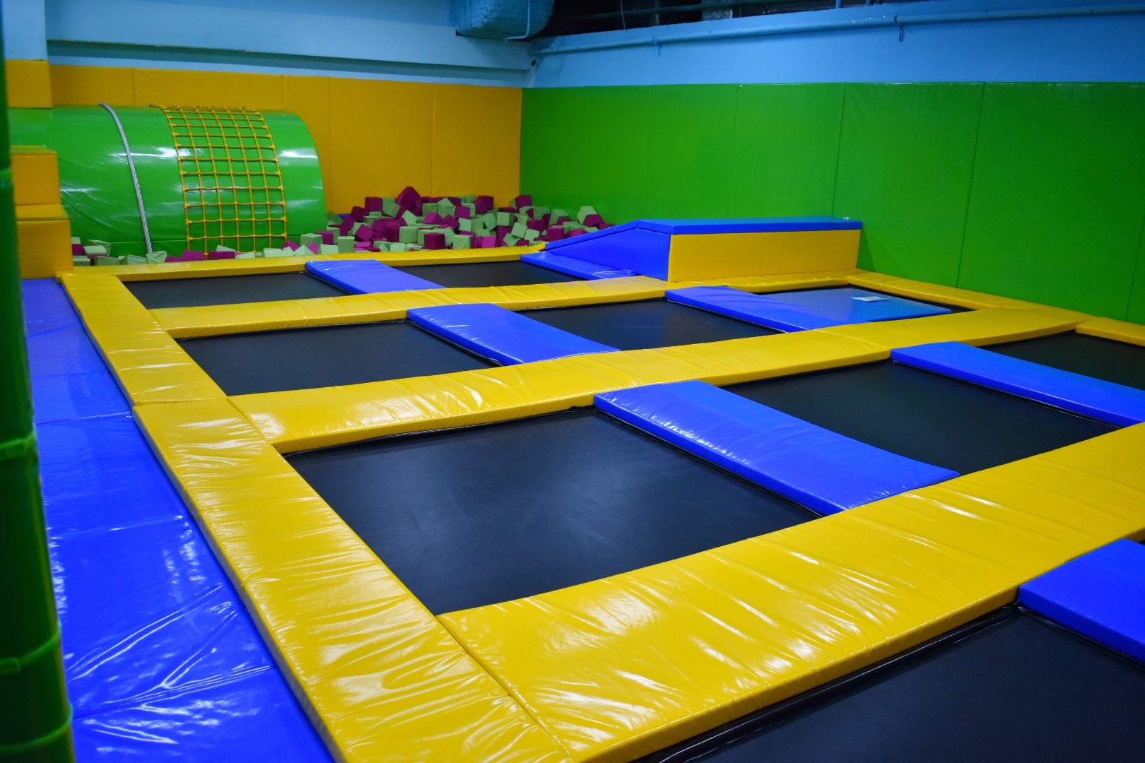 Children joyfully bouncing on colorful trampolines in a safe, supervised environment